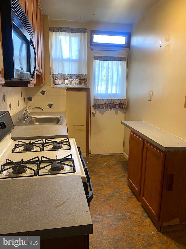 kitchen with sink, white range with gas cooktop, and tasteful backsplash