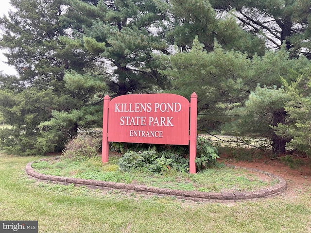 community / neighborhood sign featuring a yard