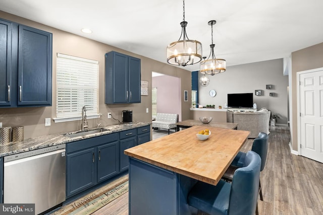 kitchen with dishwasher, sink, blue cabinetry, a center island, and a breakfast bar