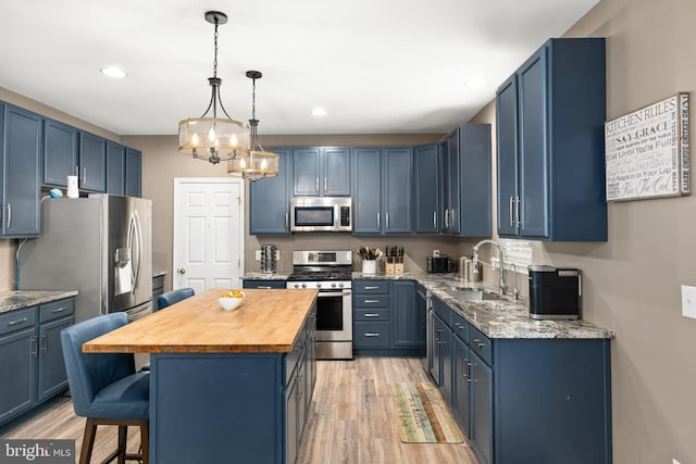 kitchen featuring blue cabinets, stainless steel appliances, and a center island