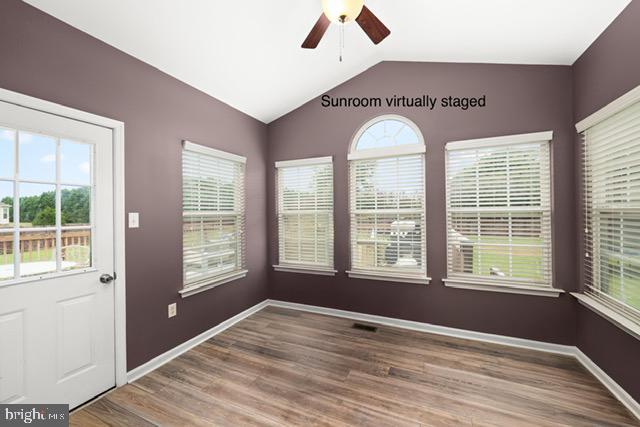 interior space with wood-type flooring, a healthy amount of sunlight, vaulted ceiling, and ceiling fan