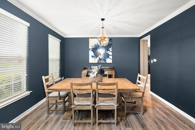 dining room with a chandelier, crown molding, and wood-type flooring