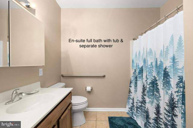 bathroom featuring vanity, toilet, walk in shower, and tile patterned floors