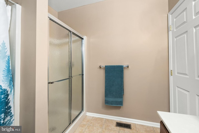 bathroom featuring tile patterned floors, walk in shower, and vanity