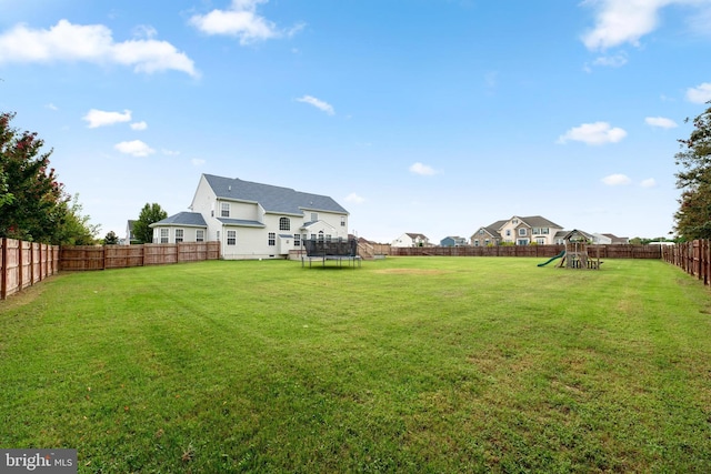 view of yard with a playground and a trampoline