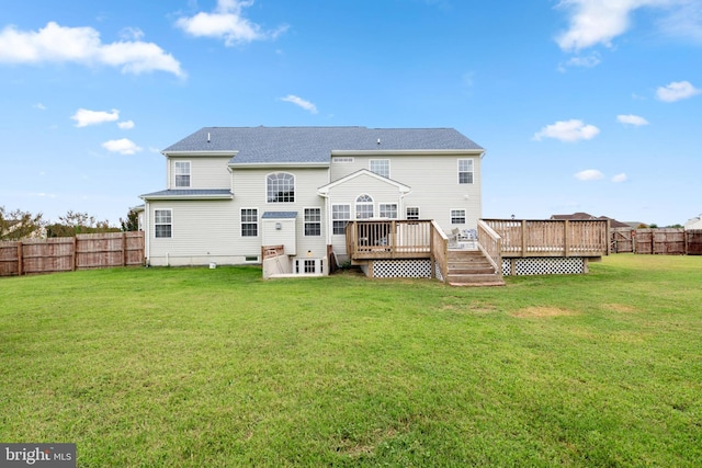 rear view of property featuring a yard and a deck