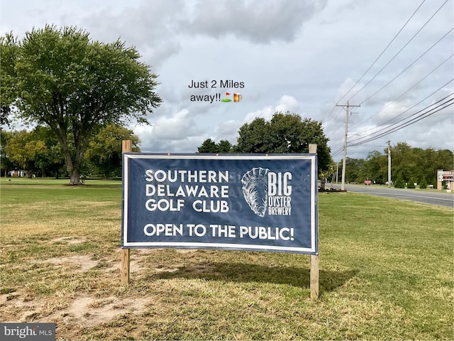 community sign featuring a yard