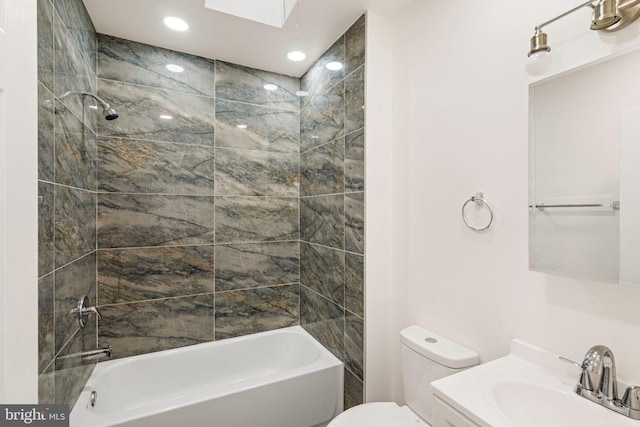 full bathroom with tiled shower / bath combo, toilet, vanity, and a skylight