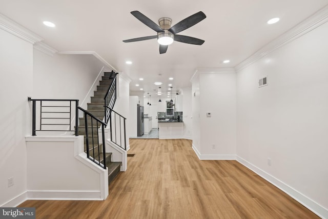 interior space featuring crown molding and light hardwood / wood-style flooring