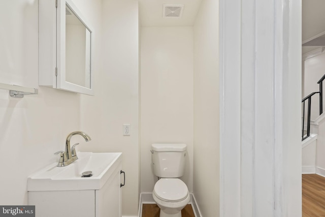 bathroom featuring vanity, hardwood / wood-style flooring, and toilet