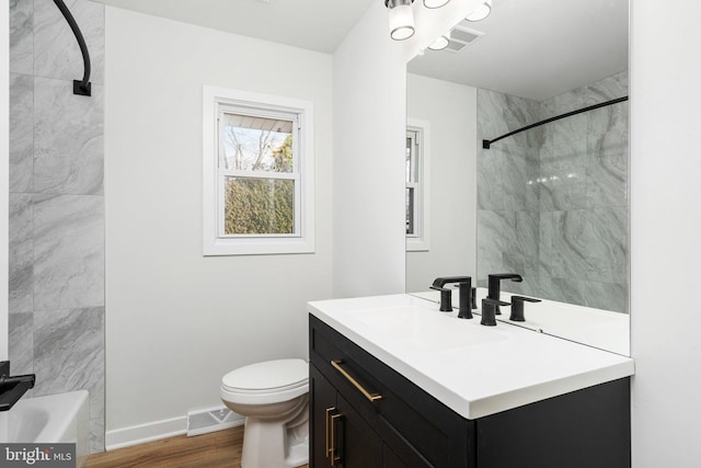 full bathroom featuring vanity, toilet, wood-type flooring, and tiled shower / bath combo