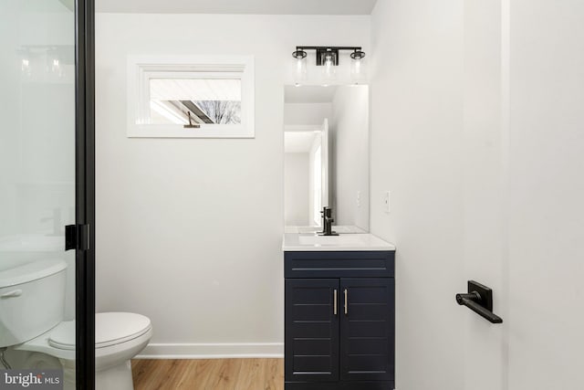 bathroom featuring vanity, wood-type flooring, and toilet