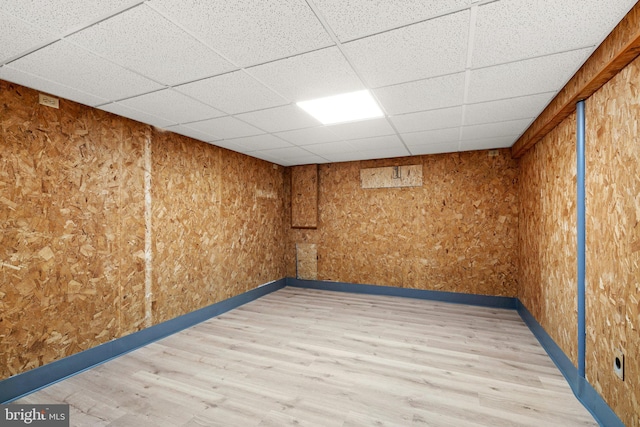 empty room with a drop ceiling and light wood-type flooring