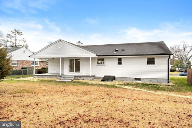 rear view of house with a lawn and a porch