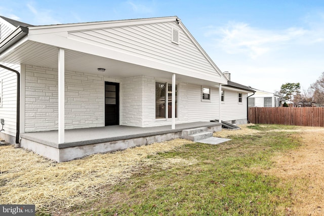 rear view of property with a lawn