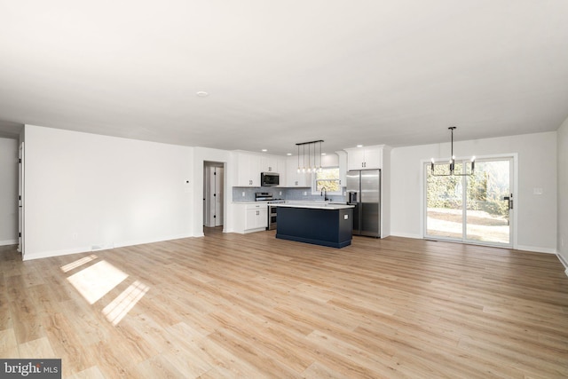 unfurnished living room featuring light hardwood / wood-style flooring, a chandelier, and sink