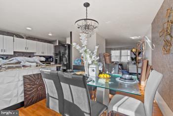 dining area featuring wood-type flooring and a chandelier