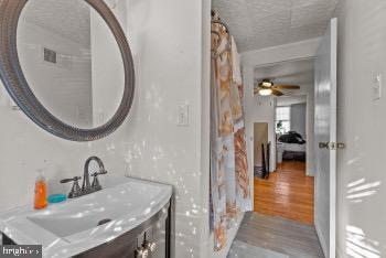 bathroom featuring vanity, hardwood / wood-style floors, a textured ceiling, and ceiling fan