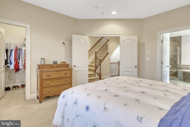 carpeted bedroom with a walk in closet, a closet, and ensuite bath