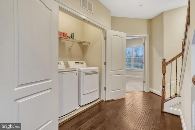 laundry room featuring washing machine and clothes dryer and dark hardwood / wood-style floors