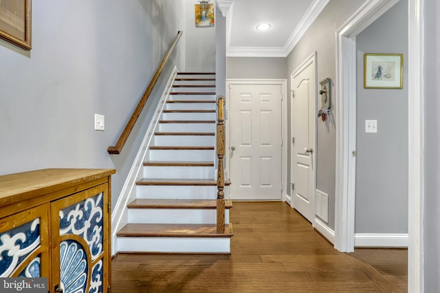 stairs featuring hardwood / wood-style floors and ornamental molding