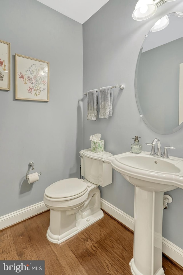 bathroom with hardwood / wood-style floors and toilet