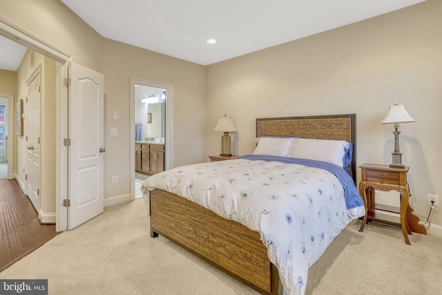 bedroom featuring light colored carpet and ensuite bath