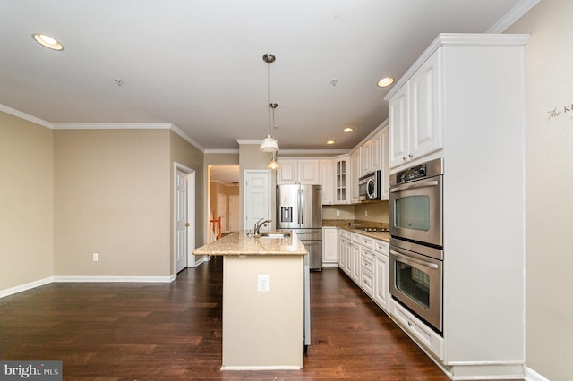 kitchen with pendant lighting, dark wood-type flooring, an island with sink, appliances with stainless steel finishes, and light stone counters