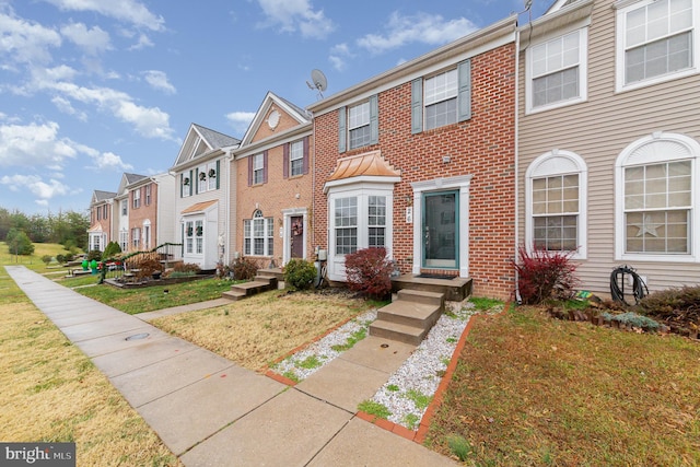 townhome / multi-family property with a front lawn