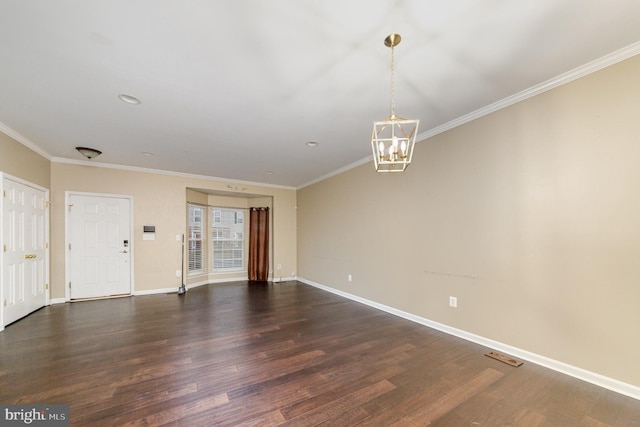 unfurnished room with dark hardwood / wood-style flooring, ornamental molding, and a notable chandelier