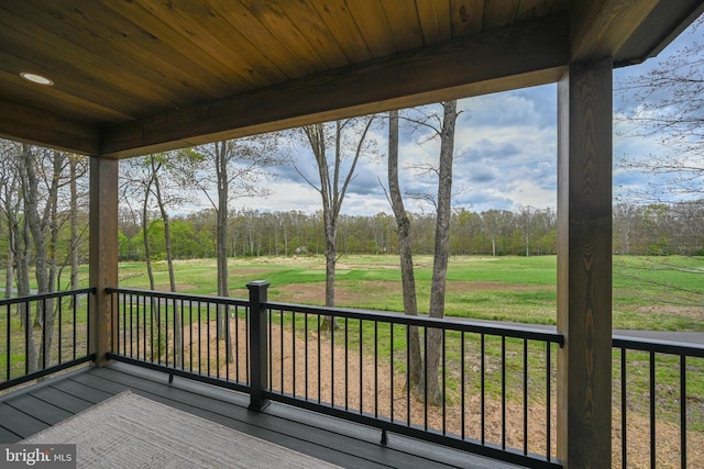 wooden terrace featuring view of wooded area