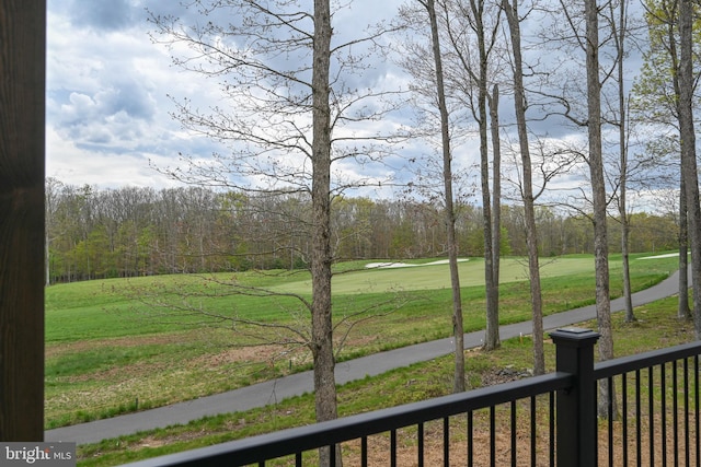 view of yard with fence and view of golf course