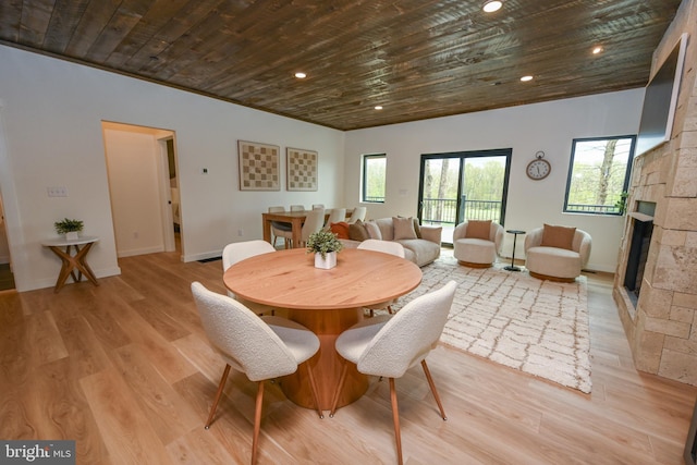 dining area featuring wooden ceiling, light wood-style floors, a fireplace, baseboards, and recessed lighting