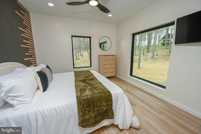 bedroom with multiple windows, light wood-style floors, recessed lighting, baseboards, and ceiling fan