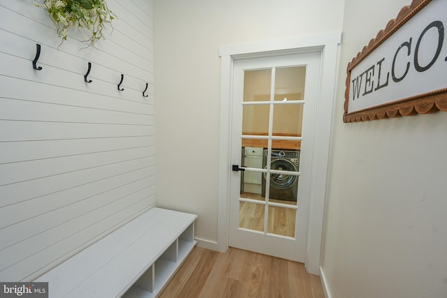 mudroom with light wood finished floors, washer / clothes dryer, and baseboards