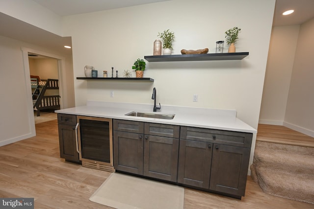 bar area with a sink, wine cooler, baseboards, light wood-type flooring, and recessed lighting