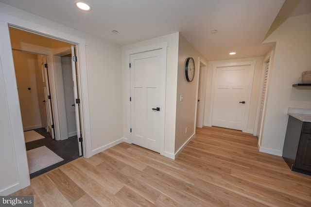 corridor featuring light wood-style floors, recessed lighting, and baseboards