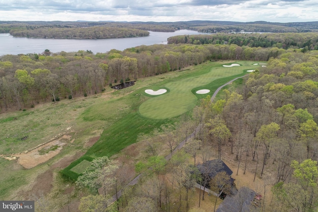 aerial view of property's location featuring a nearby body of water, a local golf course, and a heavily wooded area