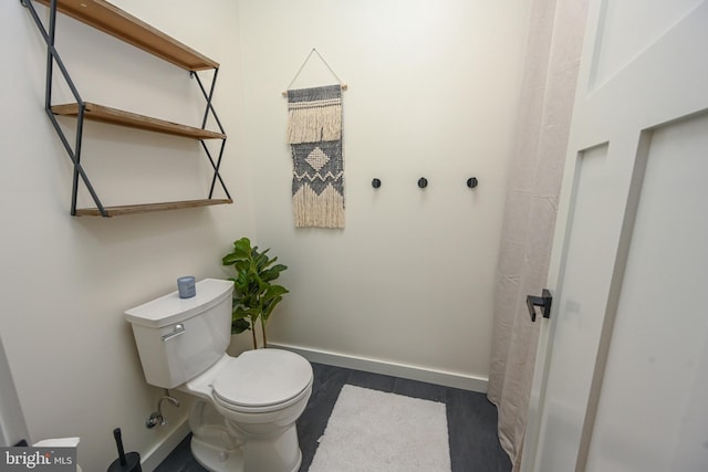 bathroom with toilet and baseboards