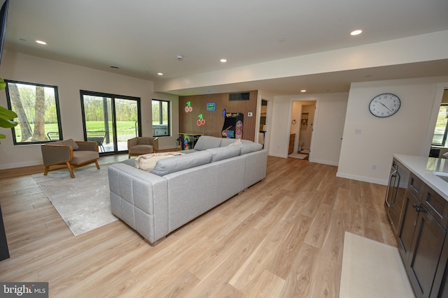 living area with baseboards, light wood-style floors, recessed lighting, and healthy amount of natural light