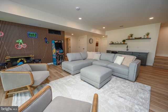 living room with wood finished floors, recessed lighting, baseboards, and bar area