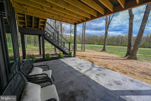 view of patio / terrace with stairway and a wooded view