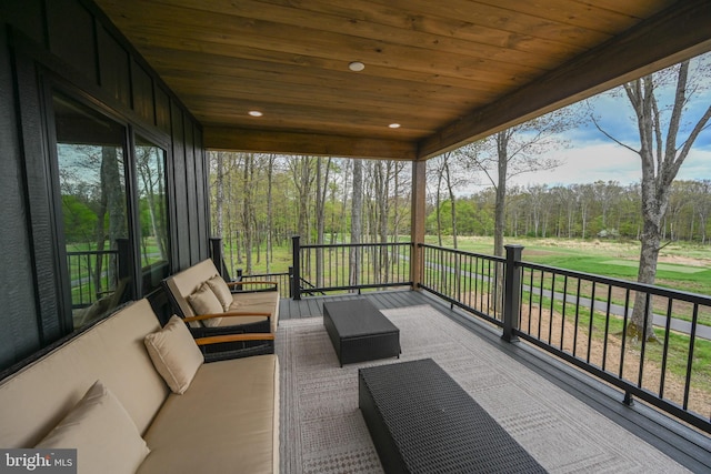 wooden terrace with an outdoor hangout area and view of scattered trees