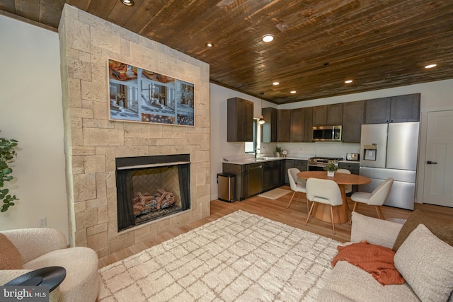 kitchen featuring stainless steel appliances, wooden ceiling, open floor plan, dark brown cabinetry, and light countertops