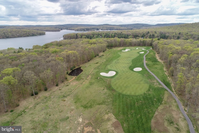 aerial view of property's location with a large body of water, a forest, and a local golf course