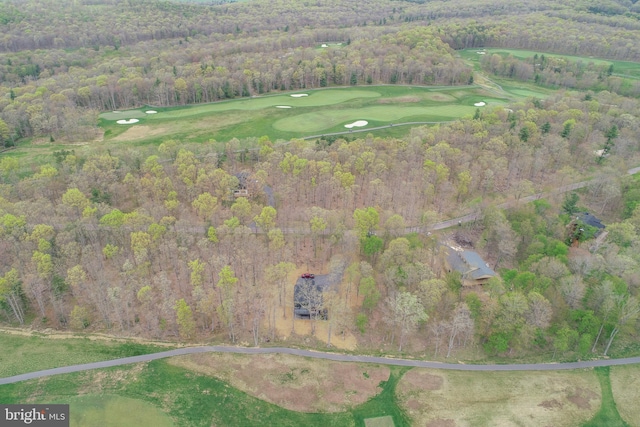 view of property location featuring a forest and a golf course