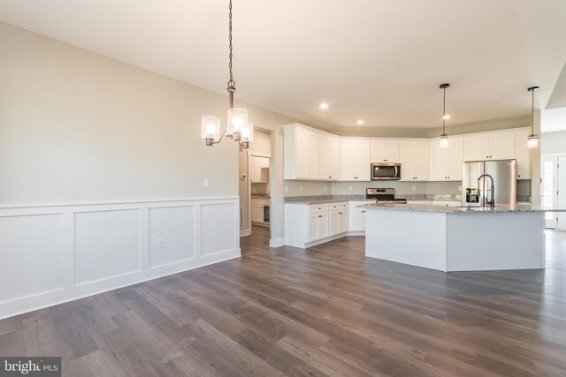 kitchen featuring white cabinetry, a center island with sink, stainless steel appliances, and dark hardwood / wood-style floors