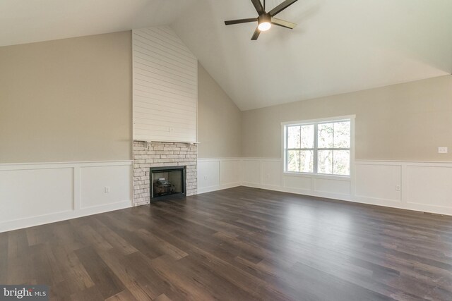 unfurnished living room with a brick fireplace, ceiling fan, dark wood-type flooring, and vaulted ceiling