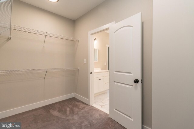 walk in closet featuring dark colored carpet