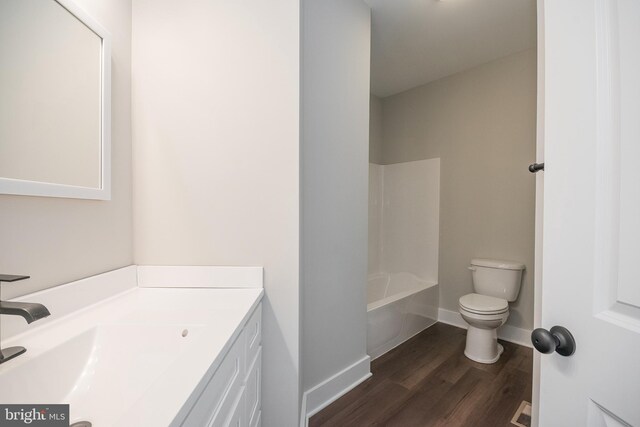 full bathroom with hardwood / wood-style floors, vanity, toilet, and shower / washtub combination